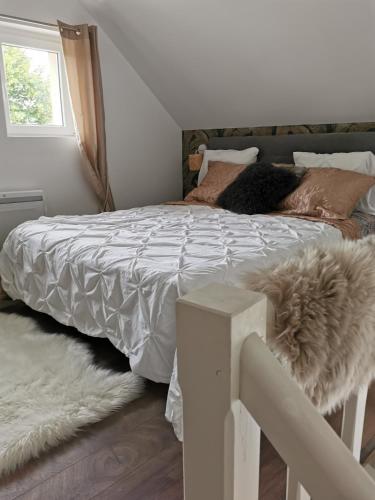 - une chambre avec un lit doté d'une couette blanche et d'une fenêtre dans l'établissement La forte maison, à Saint-Prest