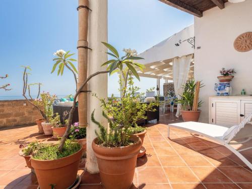 a patio with potted plants and a view of the ocean at Holiday Home Terrazza del Sud by Interhome in Porto Palo
