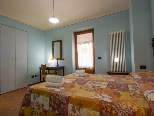 a bedroom with a large bed with two chairs at Holiday Home La Moscella by Interhome in San Romano in Garfagnana