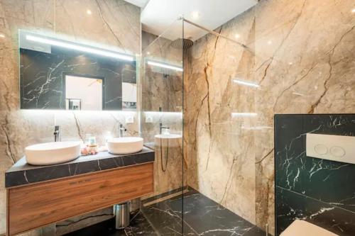 une salle de bain avec deux lavabos et un miroir dans l'établissement Le Cupidon, En plein Coeur de Lorient, à Lorient