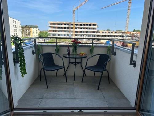 a balcony with two chairs and a table on a balcony at A&R Apartamenty Wenedów II, Parking prywatny, darmowe Wi-Fi in Koszalin