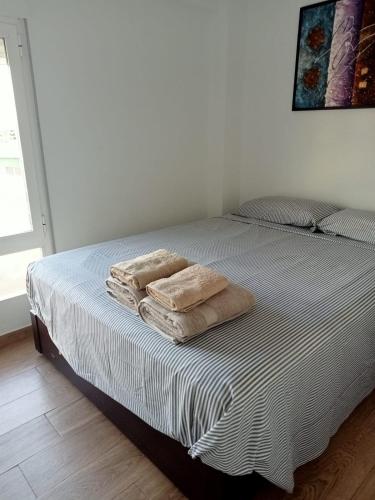 two towels sitting on a bed in a bedroom at Apartamento nuevo Playa aislada Primera línea de playa in Cullera