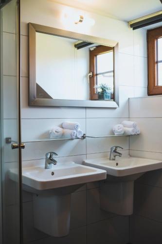 two sinks in a bathroom with two mirrors and towels at Vila nad jezerem Lipno in Lipno nad Vltavou
