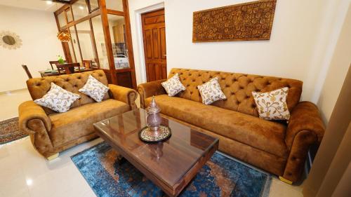 a living room with two couches and a coffee table at Walisons Homestay Abelia in Srinagar
