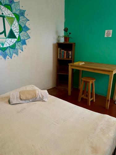 a bedroom with a bed and a wooden desk at Hostal Posada Mi Casa in San Cristóbal de Las Casas