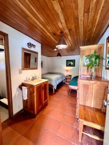 a bathroom with a bed and a sink in a room at Los Quetzales Ecolodge & Spa in Cerro Punta