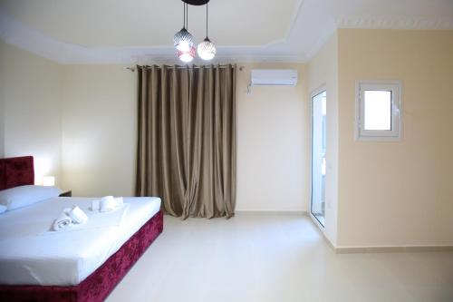 a hotel room with a bed and a window at Oasis Residence in Vlorë