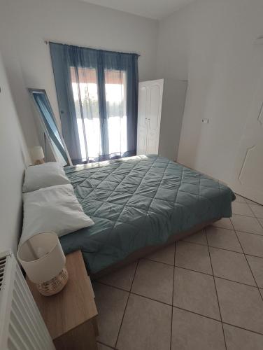 ein großes Bett in einem Zimmer mit Fenster in der Unterkunft Perdika Sunset in Pérdika