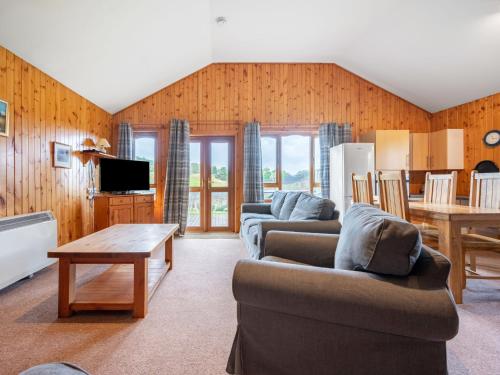 a living room with two couches and a table at Glomach Lodge at Lochletter Lodges in Drumnadrochit
