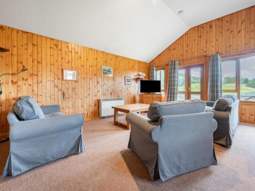 a living room with two couches and a tv at Glomach Lodge at Lochletter Lodges in Drumnadrochit