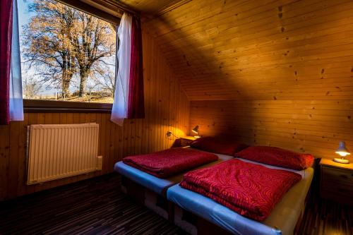 een slaapkamer met 2 bedden in een houten kamer bij chatyliptov v srdci LIPTOVA in Liptovský Trnovec