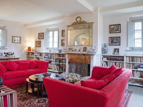 PeccioliにあるVilla Ghizzano by Interhomeのリビングルーム(赤いソファ、暖炉付)