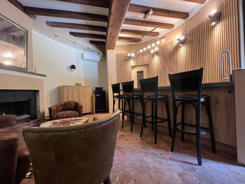 - un bar avec tabourets de bar noirs dans la chambre dans l'établissement La Tour du Château - Domainepona, à Croissy-Beaubourg