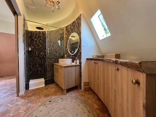 une salle de bain avec une douche avec un lavabo et un miroir dans l'établissement La Tour du Château - Domainepona, à Croissy-Beaubourg