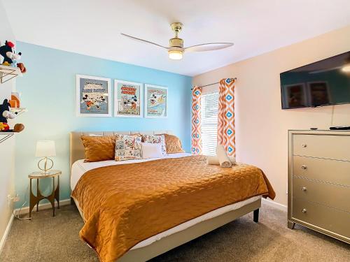 a bedroom with a bed with orange sheets and a ceiling fan at WH7742CS - Newly renovated villa in Windsor Hills in Orlando