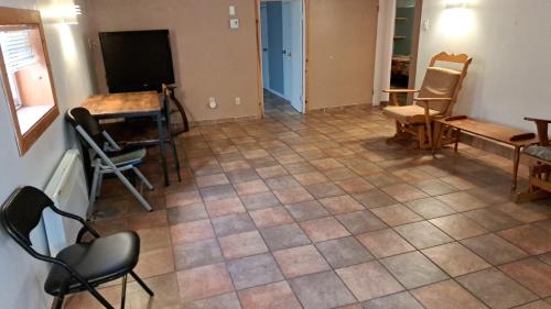 a living room with chairs and a tiled floor at Le1226-Private Basement with WIFI and Free Parking in Edmundston