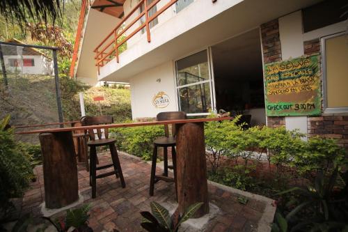 a bar with two stools in front of a building at HOTEL LA SELVA Reserva in La Vega