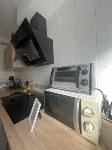 een magnetron op een aanrecht in een keuken bij Lovely Rooms en piso compartido in Sevilla