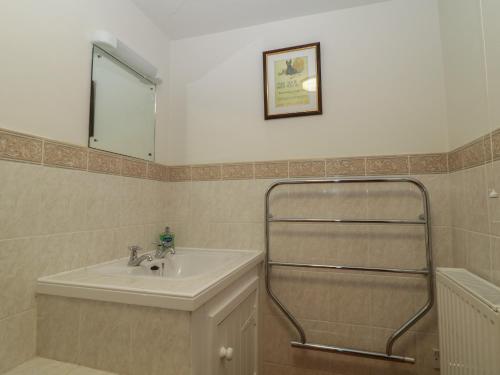 ein Badezimmer mit Waschbecken und Spiegel in der Unterkunft Beckaford Cottage in Newton Abbot