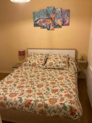 un lit avec une couette et deux tableaux au mur dans l'établissement Appartement moderne à Bagnères-de-Luchon, vue montagne, 53m², à Luchon