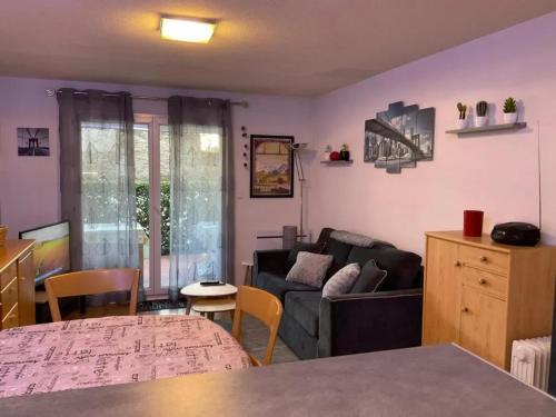 un salon avec un canapé et une table dans l'établissement Appartement moderne à Bagnères-de-Luchon, vue montagne, 53m², à Luchon