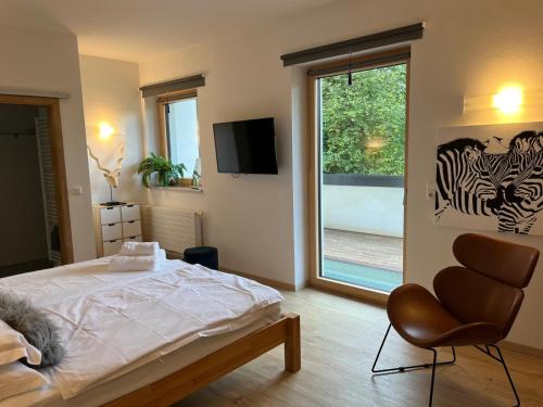 a bedroom with a bed and a chair and a window at Sprungschanze Haus in Murau