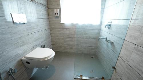 a bathroom with a white toilet and a shower at Walisons Homestay Abelia in Srinagar