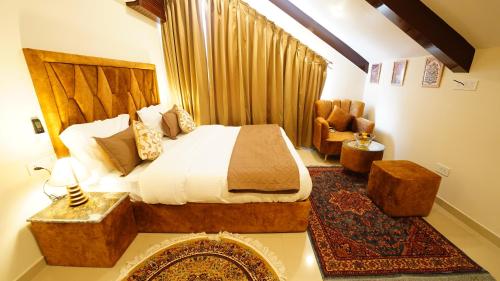 a bedroom with a bed and a couch and a chair at Walisons Homestay Abelia in Srinagar