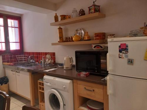 une cuisine avec un réfrigérateur et une machine à laver dans l'établissement Maison de L'Esprit Catalan Argelès-sur-Mer, à Argelès-sur-Mer
