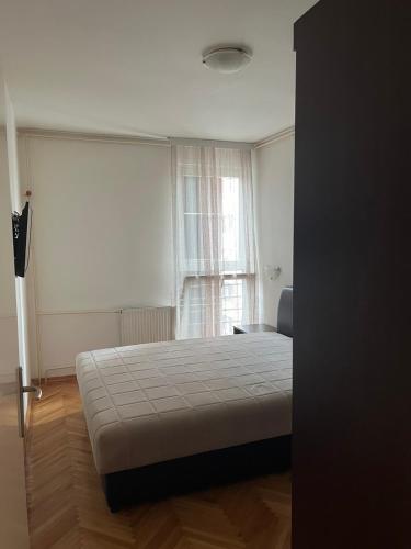 ヴァリェヴォにあるStan na dan Apartman Kovačevićのベッドと窓のある寝室