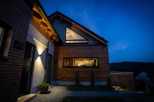 a house with a wooden facade at night at SAUERLAND CHALETS - "Die Chalets am Bergelchen" in Winterberg