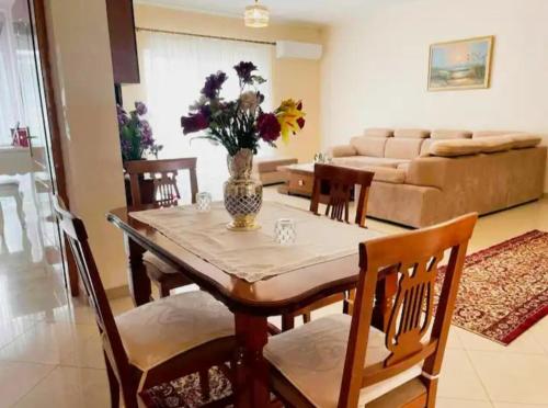 une salle à manger avec une table, des chaises et un canapé dans l'établissement Comfortable apartment, à Tirana