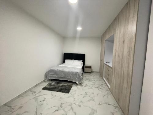 a bedroom with a bed in a white room at La Roca 101 in Cali