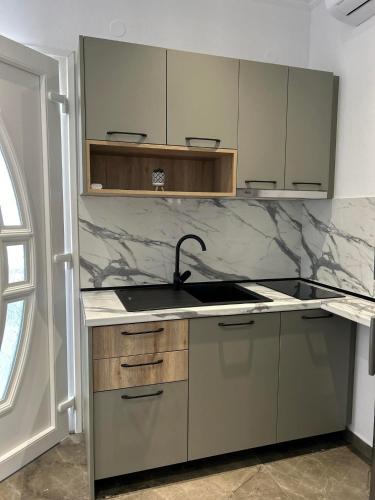 a kitchen with a sink and marble counter top at Ktima Mimoza in Sikia