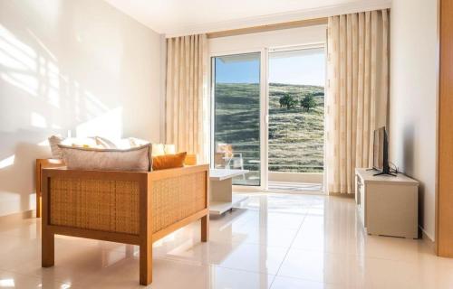 a living room with a couch and a large window at Llamani Apartments in Himare
