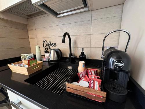 a kitchen counter with a sink with a coffee maker at Botanic Exclusive Room in Pescara
