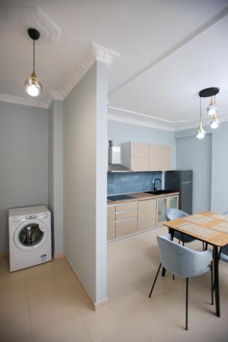 a kitchen with a table and a washing machine at Oasis Residence in Vlorë