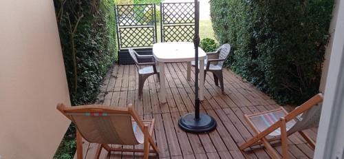 une terrasse avec deux chaises, une table et une lampe dans l'établissement F2 en rez de jardin, à Cabourg