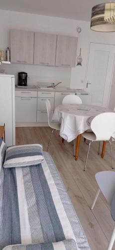 une cuisine avec une table et des chaises dans une pièce dans l'établissement F2 en rez de jardin, à Cabourg