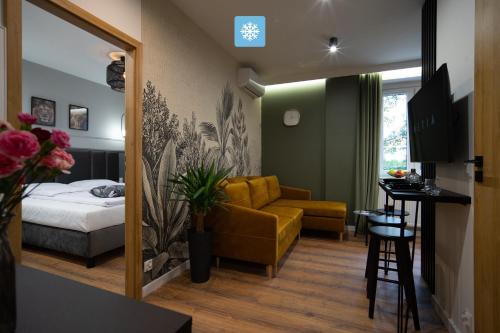 a hotel room with a bed and a yellow couch at FLATMORE Apartament Akacjowa 17m1B in Zielona Góra