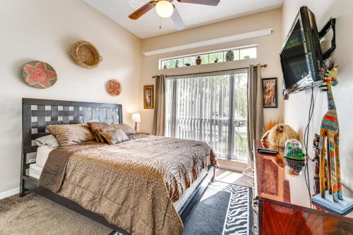 a bedroom with a bed and a tv and a window at Disney-Themed Villa with Heated Pool, 10 Mi to Parks in Kissimmee