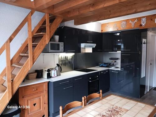 une cuisine avec des armoires bleu foncé et un escalier dans l'établissement Résidence Arandelieres - Beau duplex pour 6 personnes, au coeur de la station d'Arc 1800 MAE-7261, à Arc 1800