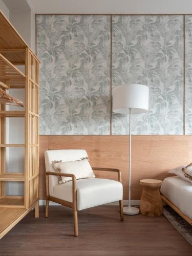 une chambre avec un lit, une chaise et une lampe dans l'établissement Le Vercors - Gare - CEA - STMicro, à Fontaine