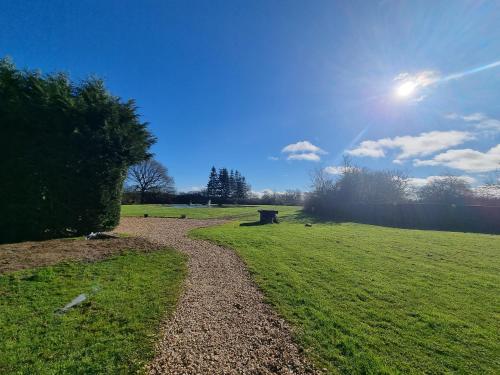 a path in a field with the sun in the sky at The Limes Country Lodge Hotel & Admiral Restaurant in Solihull