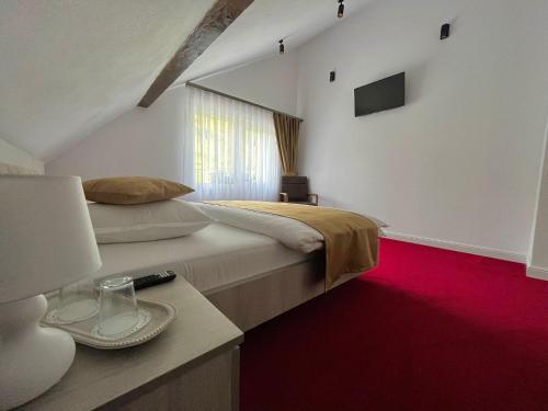 a bedroom with a large bed and a red carpet at Casa Bobu Arieseni in Arieşeni