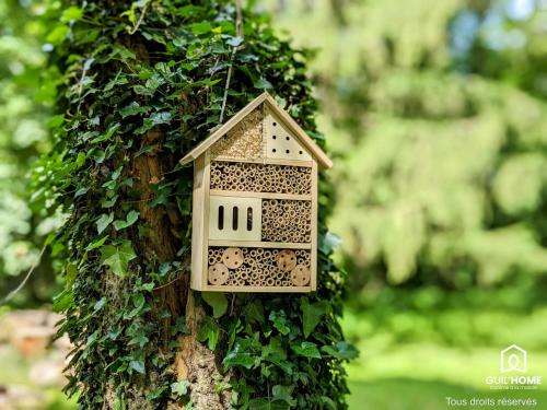 une maison ornithologique est attachée à un arbre dans l'établissement Les Charmes - Climatisation - Terrasse - Nature, à Boigny-sur Bionne