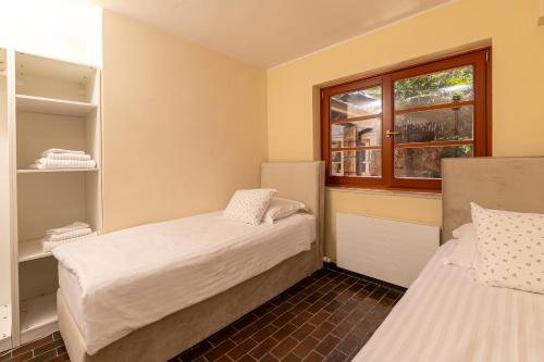 two beds in a small room with a window at Villa Gallus - Jelsa, Hvar in Jelsa