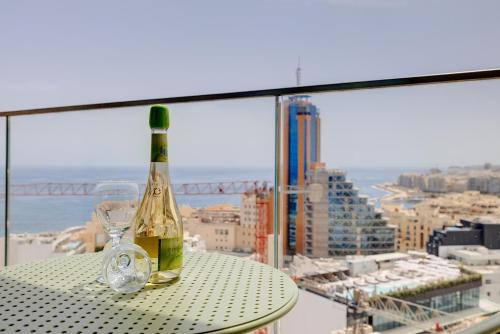 a bottle of wine sitting on a table with a glass at Mercury Tower Apartments in St Julian's