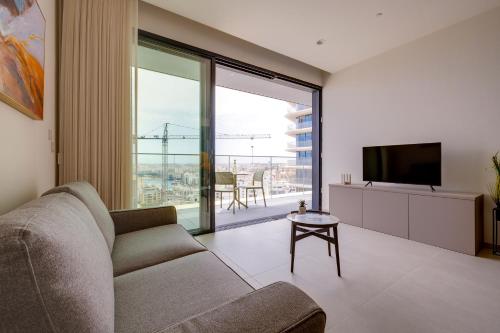 a living room with a couch and a television at Mercury Tower Apartments in St Julian's