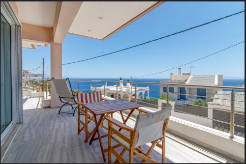 a balcony with a table and chairs and the ocean at Amazing villa with a magic view to the Aegean in Dhaskalión